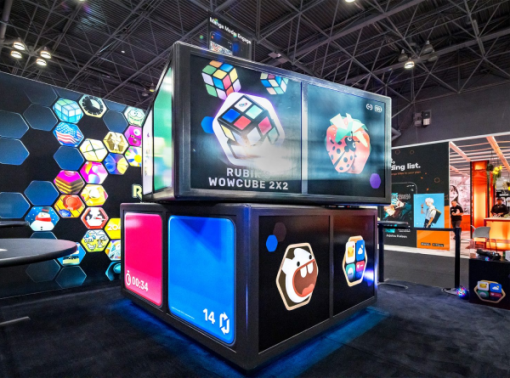 Rubik's WowCube 2x2 promotional display with colorful cube graphics and illuminated product panels at an expo.