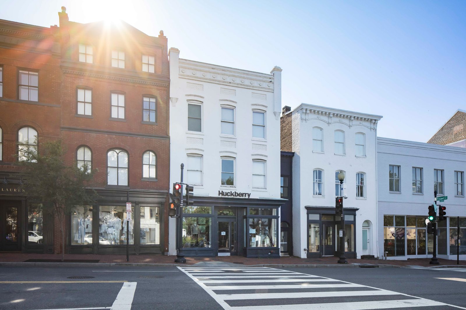 Huckberry storefront in a row of historic brick buildings beside a marked crosswalk