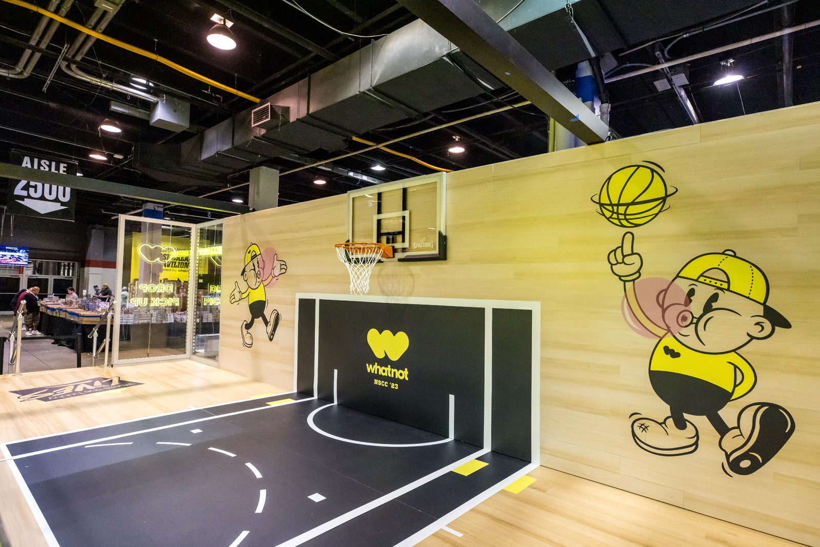 Whatnot NSCC ’23 booth featuring a miniature basketball court, hoop, and cartoon basketball player