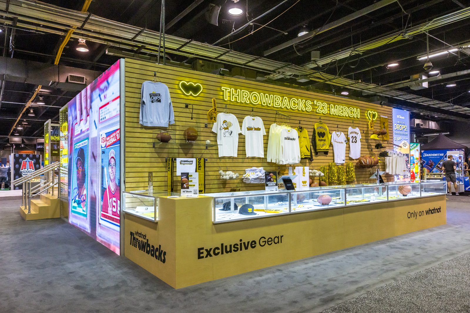 Whatnot Throwbacks ’23 merchandise booth displaying sports jerseys, shirts, hats, balls, and memorabilia.