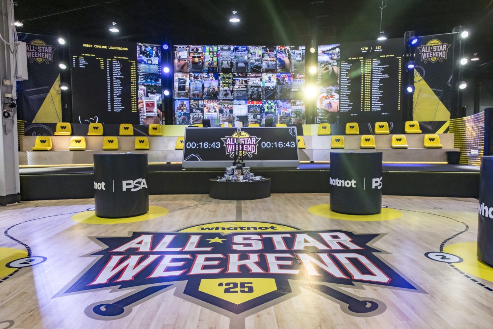 Whatnot All Star Weekend ’25 trading stage with PSA-branded podiums, card displays, scoreboards, and yellow seating