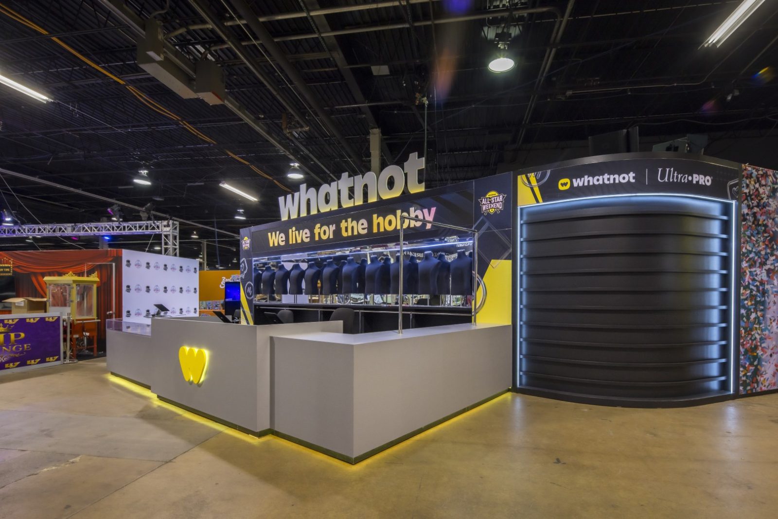 Whatnot and Ultra PRO trade show booth displaying the slogan “We live for the hobby” and rows of merchandise displays.
