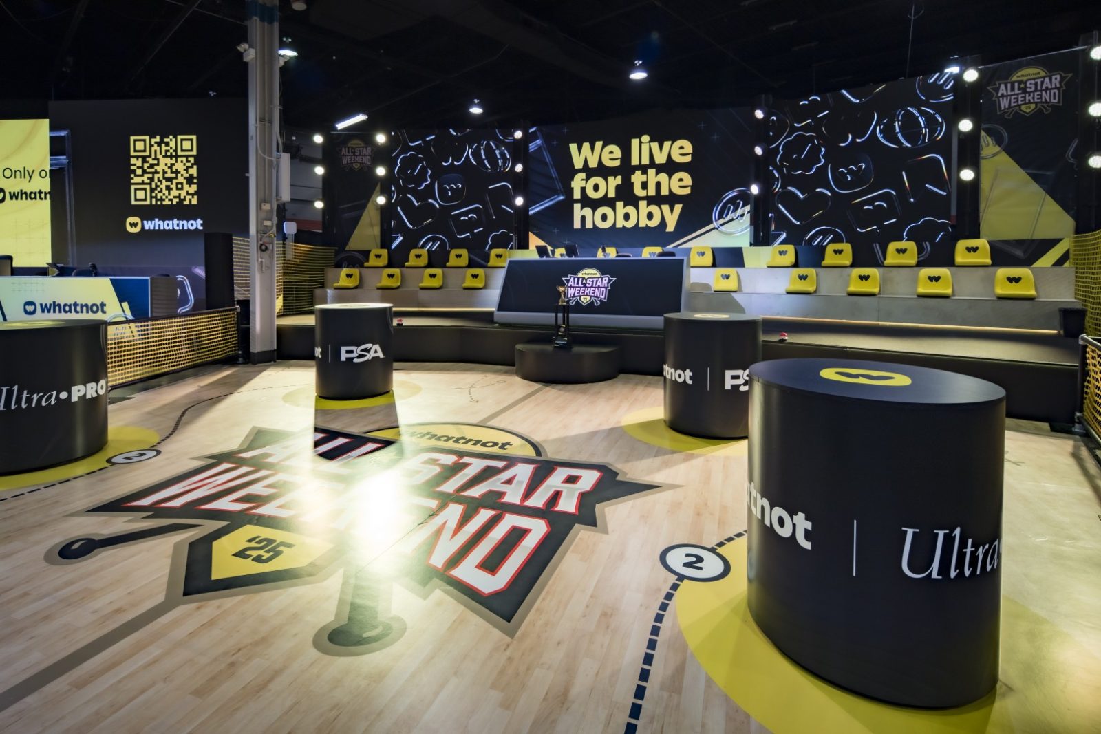 Whatnot All-Star Weekend booth with a basketball-themed court, yellow seating, and a display reading “We live for the hobby.”