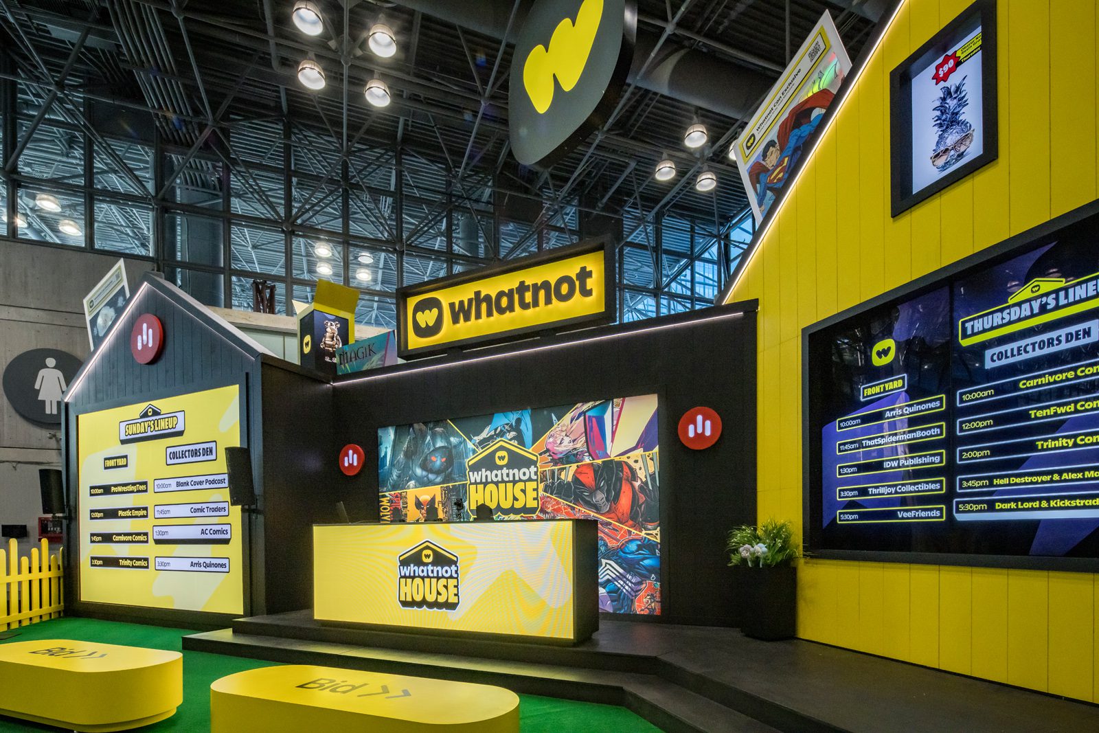Whatnot House event booth with yellow branding, comic artwork, stage, and schedule displays