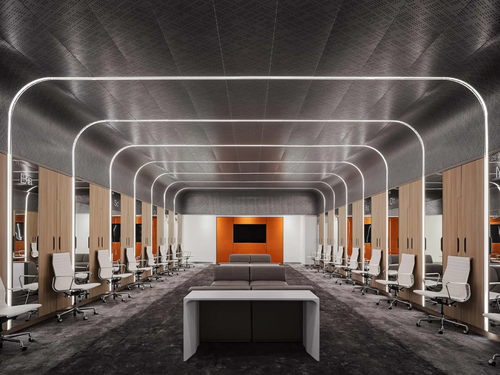Modern Phoenix Mercury locker room with rows of wood lockers, white chairs, illuminated archways, and a central lounge area