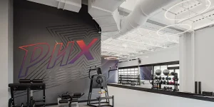 Basketball training gym with exercise equipment, medicine balls, and a large PHX wall logo