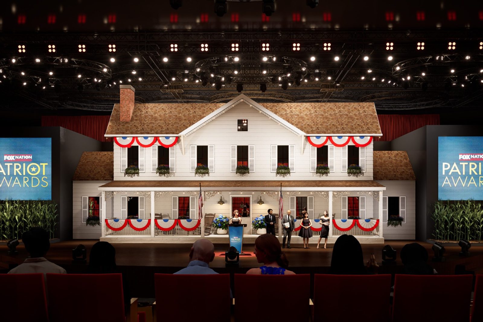 House-front stage set with presenters at the Fox Nation Patriot Awards, viewed from a seated audience.