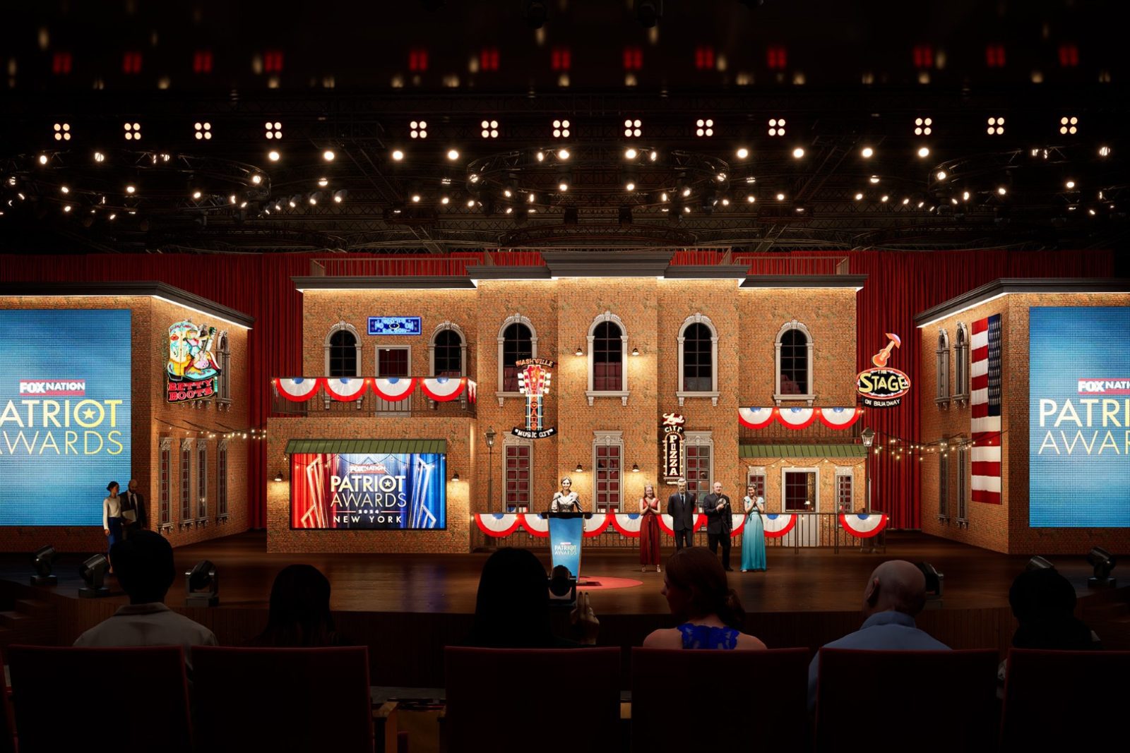 The Patriot Awards New York stage at the Grand Ole Opry, with presenters onstage before a brick building backdrop and audience seating.