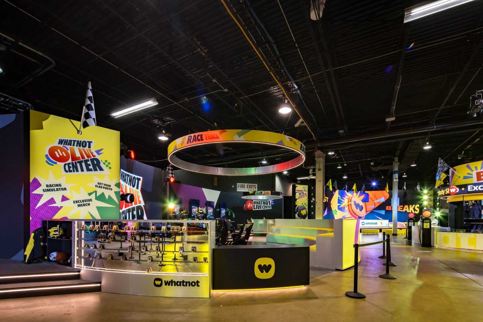 Whatnot Live Center interior with racing simulators, merchandise displays, colorful event signage, and arcade-style attractions