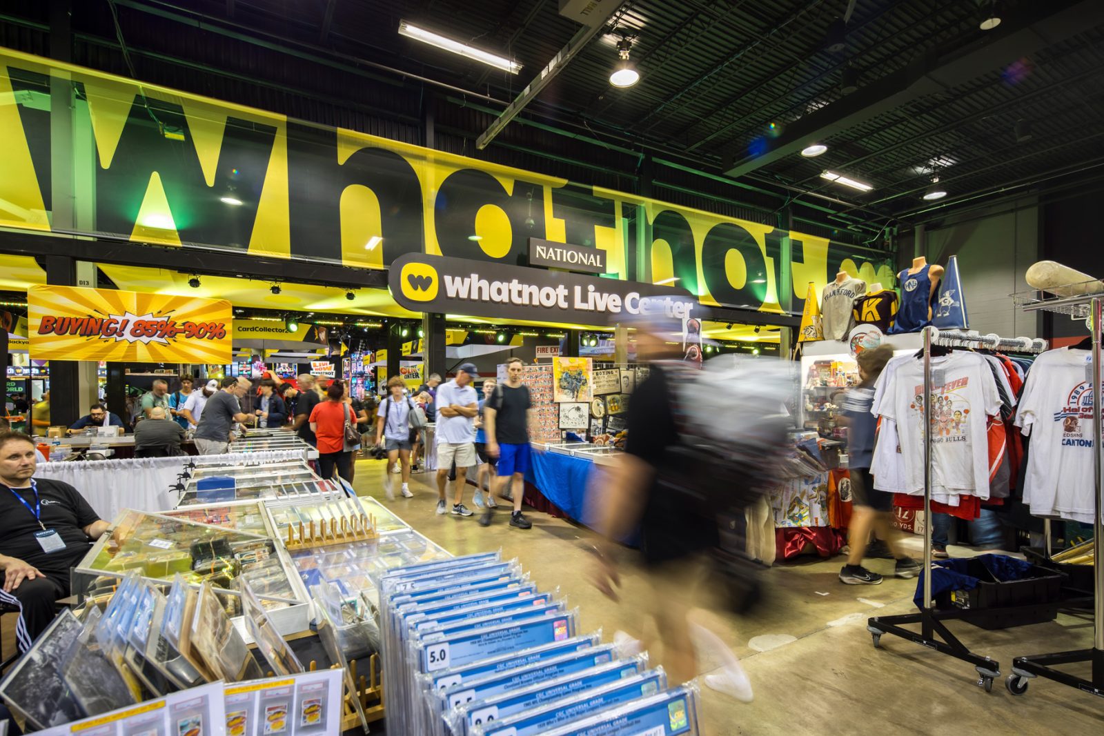Whatnot Live Center at a busy collectibles convention, with trading cards, sports apparel, and shoppers in the exhibition hall.