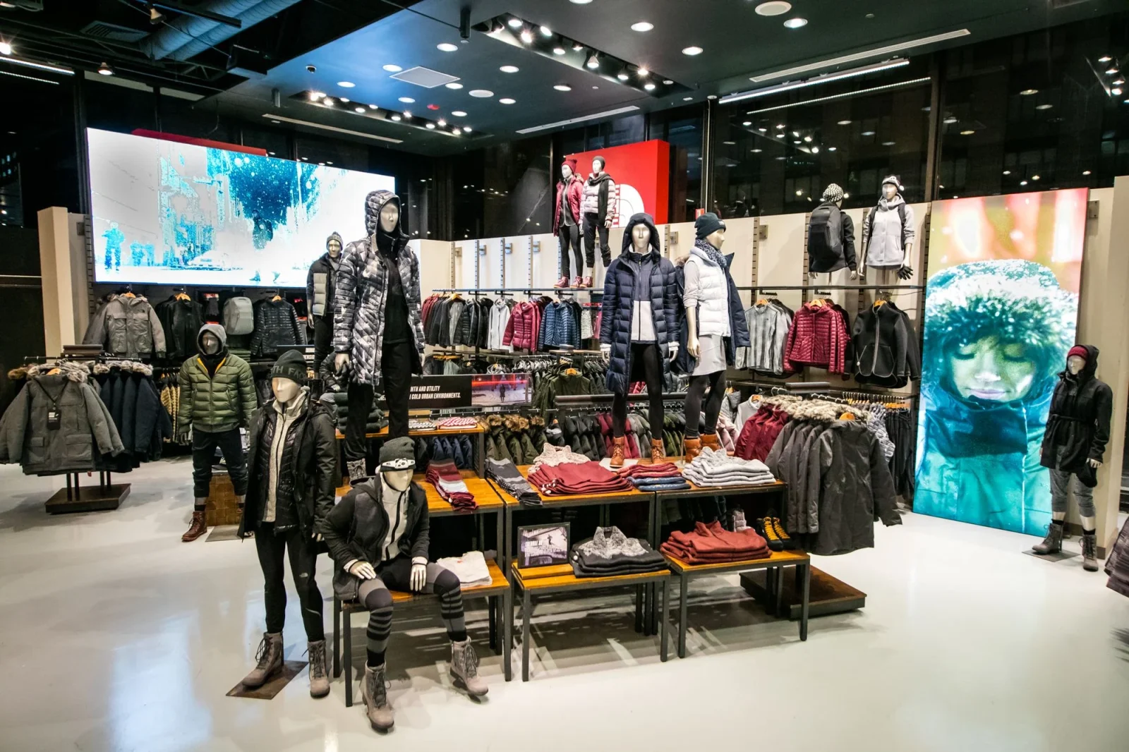 The North Face retail store displaying winter jackets, clothing, and accessories on mannequins and racks.