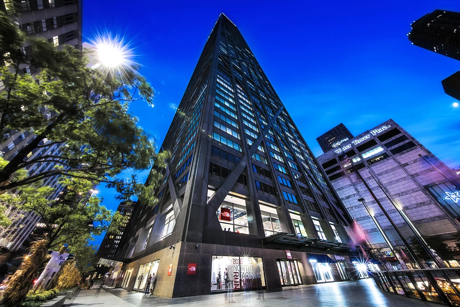 The North Face store at White Tower Place beneath a tall downtown office building at dusk