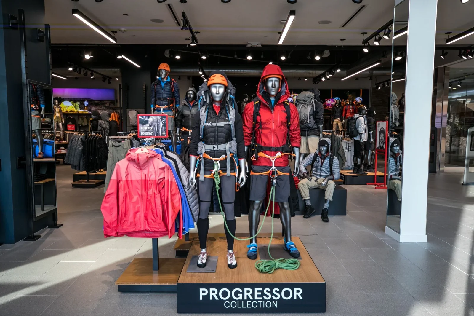 Store display of mannequins in climbing gear beneath a sign reading “PROGRESSOR COLLECTION.”
