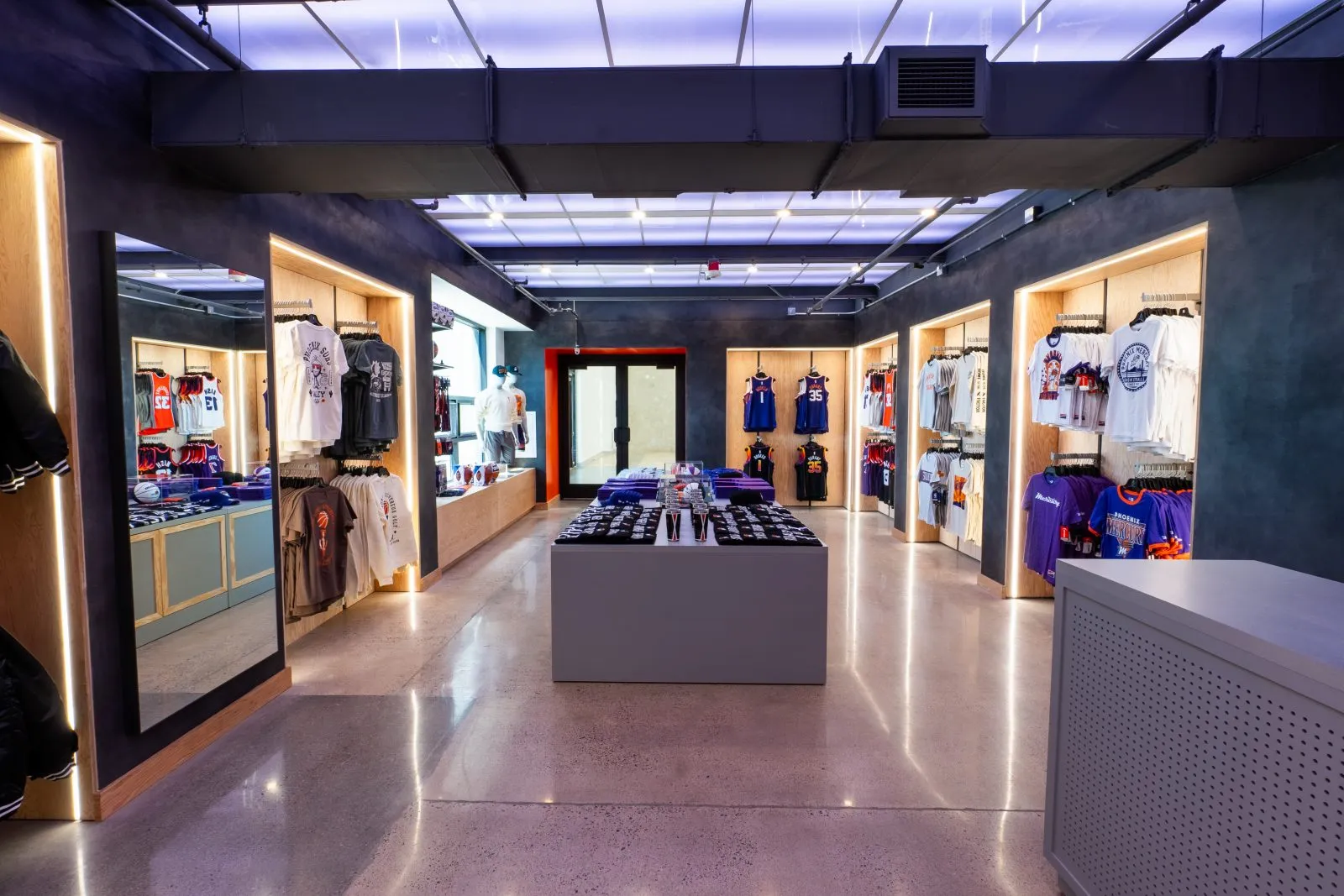 Interior of a Phoenix Suns team store displaying jerseys, T-shirts, hats, and other basketball merchandise.