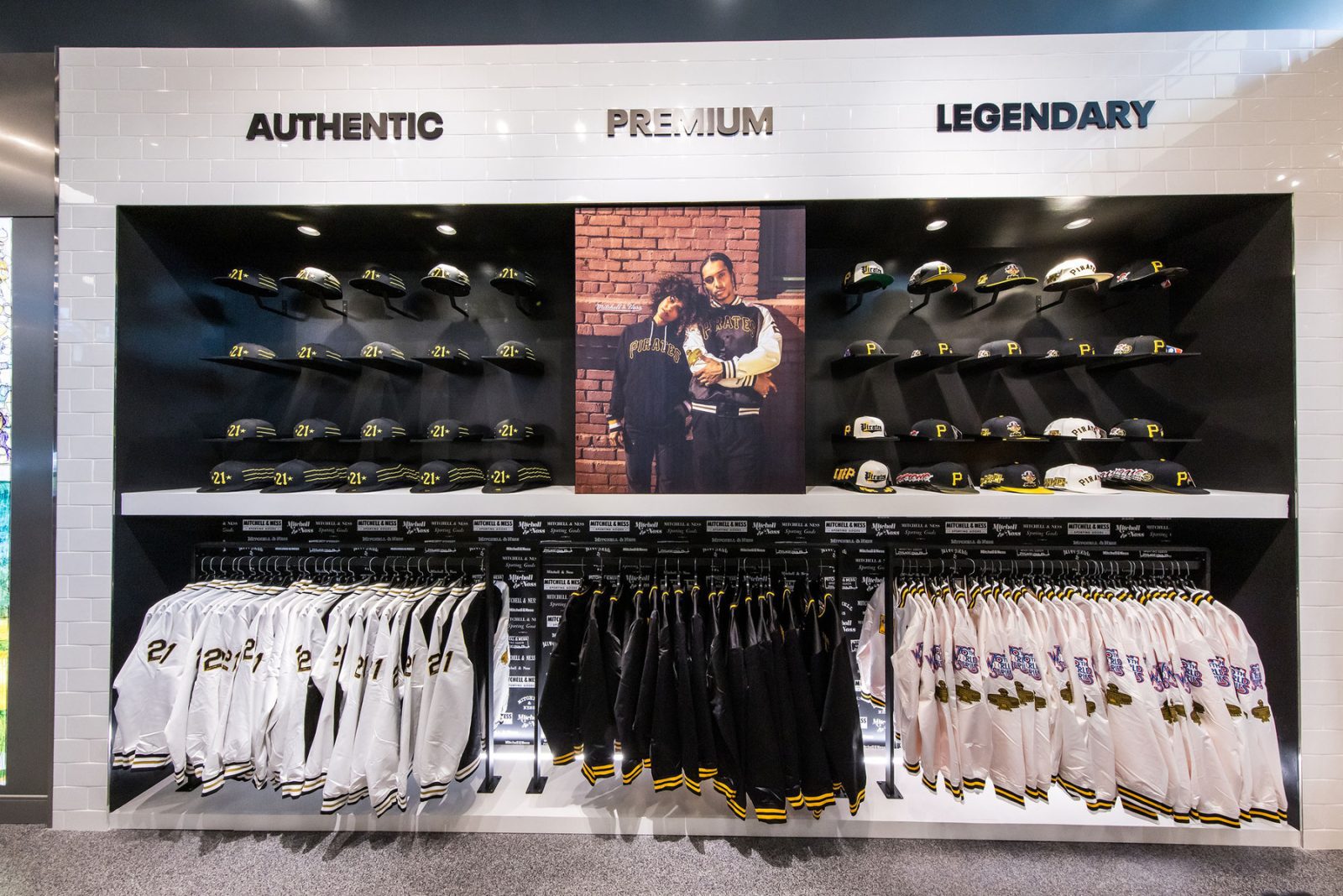 Pittsburgh Pirates team store display with caps, jackets, jerseys, and a central player mural beneath the words “Authentic Premium Legendary.”