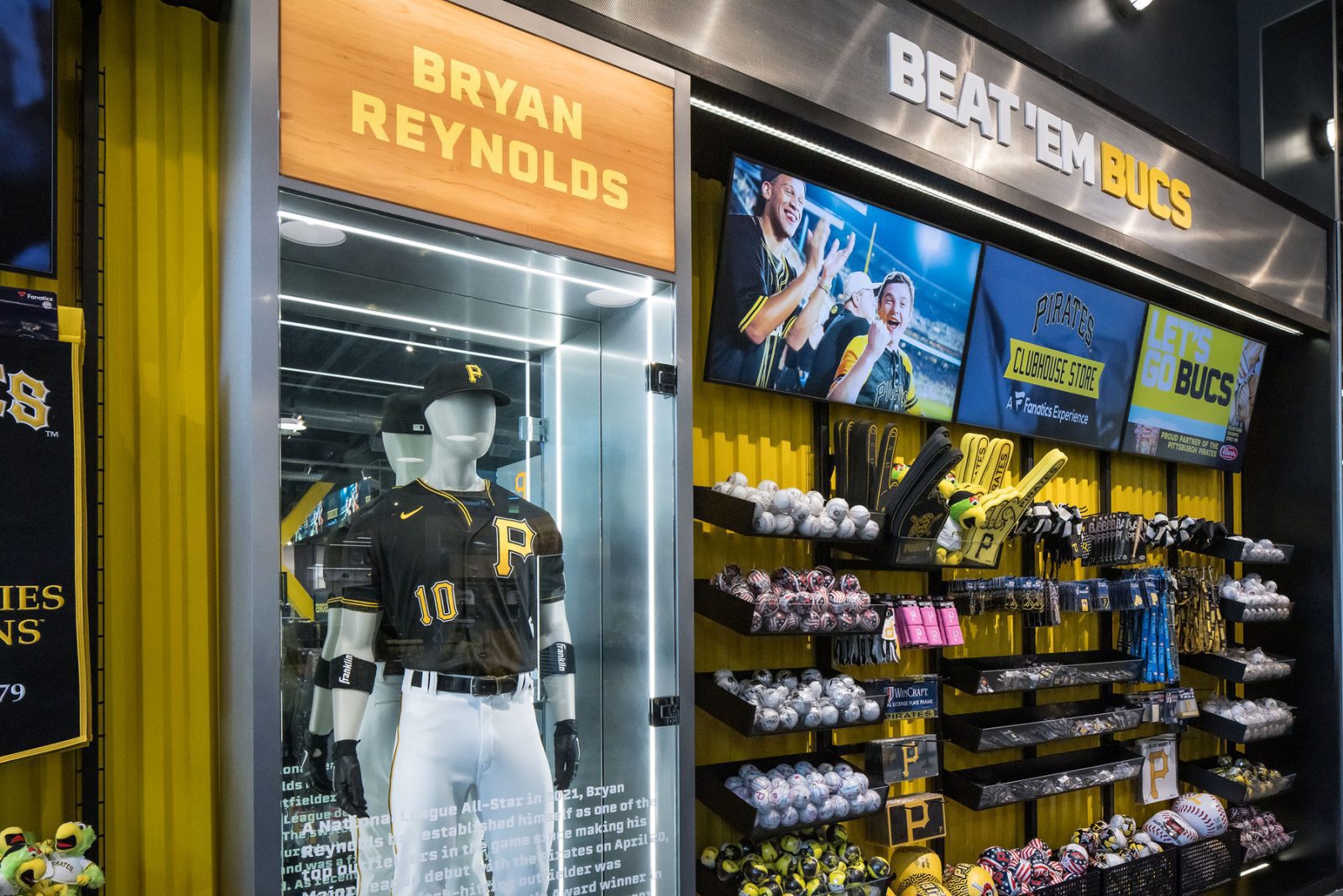 Pittsburgh Pirates clubhouse store display with a Bryan Reynolds mannequin, team merchandise, and signs reading “Beat ’Em Bucs.”