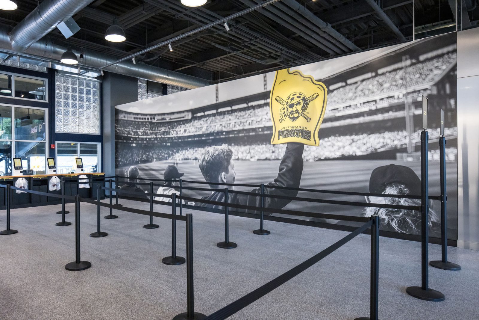 Pittsburgh Pirates store interior with queue barriers, ticket kiosks, and a large stadium mural featuring the Pirates logo.