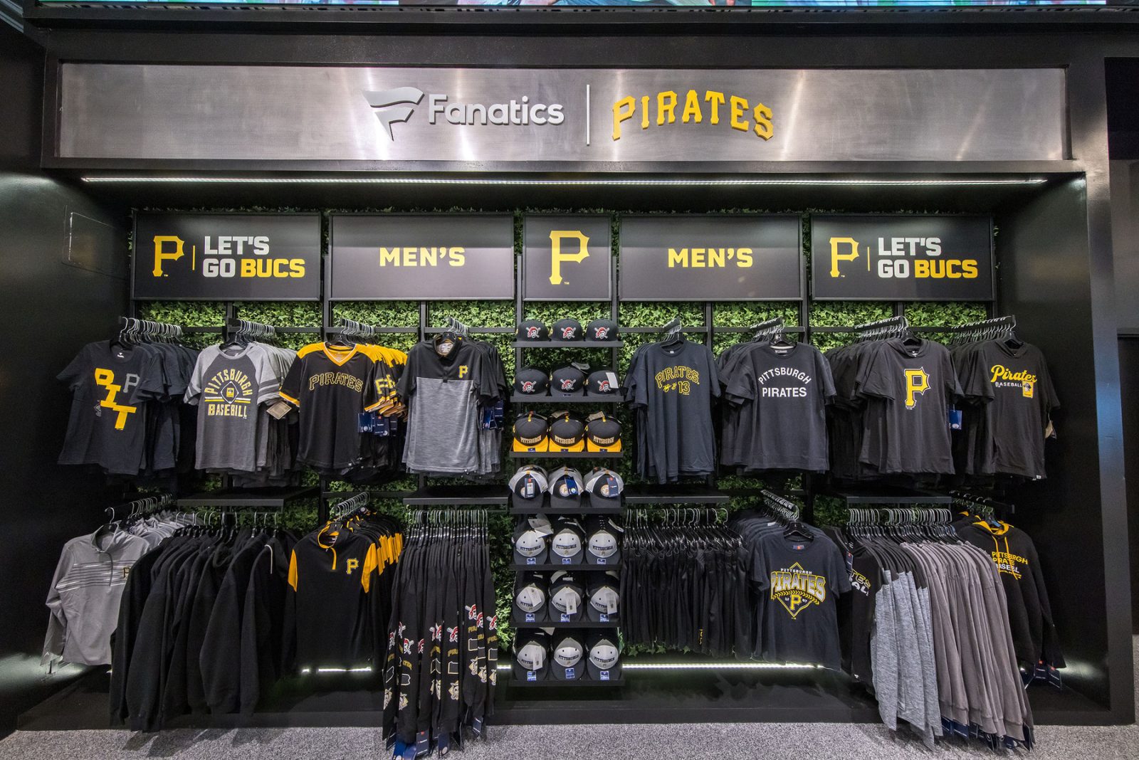 Pittsburgh Pirates Fanatics store display with team apparel, caps, and signage reading “Let’s Go Bucs” and “Men’s.”