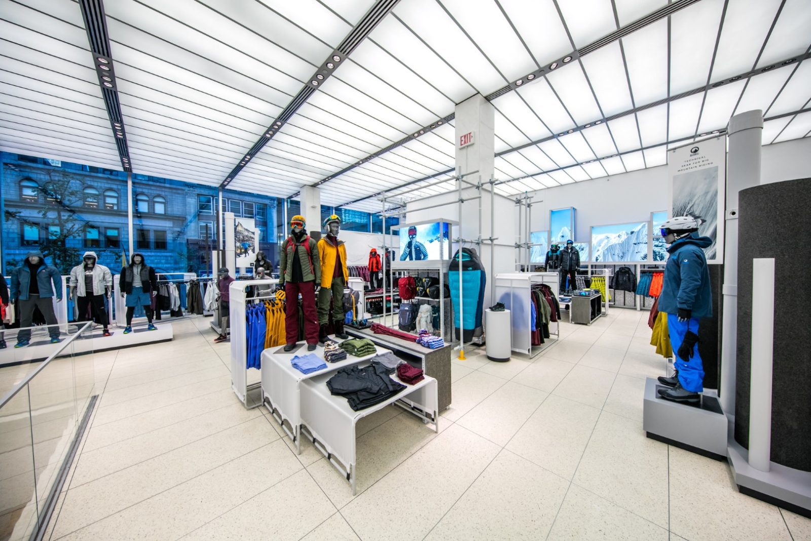 Interior of an outdoor apparel store with mannequins displaying jackets, snow gear, and winter clothing.